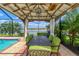 Covered cabana offering views of the lake, containing seating for six around an iron table at 18032 Polo Trl, Bradenton, FL 34211