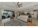 Living room featuring tile floors, neutral paint, a ceiling fan, and sliding glass doors opening to a pool at 18032 Polo Trl, Bradenton, FL 34211