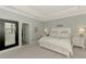 Bright main bedroom featuring neutral colors, tray ceilings, and modern decor at 18032 Polo Trl, Bradenton, FL 34211