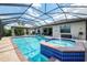 Enjoy this screened in pool with jacuzzi and lake views, connected to a covered outdoor patio at 18032 Polo Trl, Bradenton, FL 34211