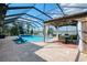 Relax in this screened-in pool area featuring a jacuzzi, covered cabana, and tranquil lake views at 18032 Polo Trl, Bradenton, FL 34211