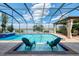 Enjoy this screened in pool with a view of the lake, equipped with a connected jacuzzi and a cabana with seating at 18032 Polo Trl, Bradenton, FL 34211