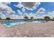 Community pool features a beach entry, brick paver deck, and views of the surrounding lake and lush landscaping at 18032 Polo Trl, Bradenton, FL 34211
