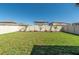 Expansive backyard with lush green lawn, privacy fence, and tropical landscaping at 22111 Nebula Way, Land O Lakes, FL 34637