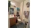 Compact bathroom with a wood vanity, decorative shelf, and toilet with plush rugs and decor at 227 Golden Harbour Trail Way, Bradenton, FL 34212