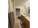 Neutral toned bathroom with double sink vanity, linen closet, shower-tub combo and motivational wall decor at 227 Golden Harbour Trail Way, Bradenton, FL 34212