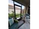 Enclosed lanai with comfortable wicker furniture and a view of the backyard and landscaping at 227 Golden Harbour Trail Way, Bradenton, FL 34212