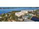 Aerial view of a low-rise residential building and community amenities, including tennis courts, and a waterfront view at 280 Hidden Bay Dr # 202, Osprey, FL 34229