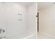 Bathroom with a white tiled tub and wall niche, adjacent to an open doorway at 280 Hidden Bay Dr # 202, Osprey, FL 34229
