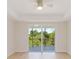 Bright bedroom featuring light hardwood floors and a sliding glass door to a balcony with a beautiful green view at 280 Hidden Bay Dr # 202, Osprey, FL 34229