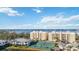 Low-rise condo building featuring bright architecture, tennis courts, and scenic water views on a sunny day at 280 Hidden Bay Dr # 202, Osprey, FL 34229