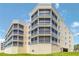 Multi-story residential building with light yellow paint and white accents, featuring screened balconies at 280 Hidden Bay Dr # 202, Osprey, FL 34229