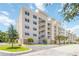 Multi-story residential building with light yellow paint and white accents with parking at 280 Hidden Bay Dr # 202, Osprey, FL 34229
