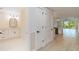 Elegant hallway with a bathroom vanity, closet, and view of the modern kitchen and balcony at 280 Hidden Bay Dr # 202, Osprey, FL 34229