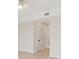 Hallway featuring light hardwood floors, white walls, and a pair of white doors with black hardware at 280 Hidden Bay Dr # 202, Osprey, FL 34229