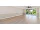 Spacious living room with a ceiling fan, natural light, and balcony access at 280 Hidden Bay Dr # 202, Osprey, FL 34229