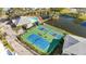 Aerial view of tennis courts and a pool area, offering a vibrant recreational space within a well-maintained community at 280 Hidden Bay Dr # 202, Osprey, FL 34229