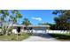 Charming single-story home with a well-manicured lawn, mature trees, and a paved driveway at 3013 Yarmouth W Dr, Bradenton, FL 34205