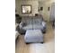 Cozy seating area with a gray love seat and ottoman, perfect for relaxing at 3013 Yarmouth W Dr, Bradenton, FL 34205