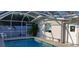 Screened-in pool with ladder entry and lounge chairs surrounded by tropical landscaping at 3013 Yarmouth W Dr, Bradenton, FL 34205