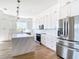 Bright kitchen features white cabinets, a subway tile backsplash, stainless steel appliances and a marble topped island at 309 Sunset Rd, Rotonda West, FL 33947