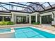 Backyard pool area with a screened-in enclosure and beautiful landscaping at 329 Bird Key Dr, Sarasota, FL 34236