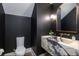 Modern powder room with dark walls, marble sink, and a gold-trimmed mirror at 329 Bird Key Dr, Sarasota, FL 34236