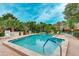 Community pool with plenty of lounge chairs, tables and blue umbrellas for relaxing outdoors at 333 Springdale Dr # 333, Bradenton, FL 34210