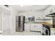 Kitchen with stainless steel refrigerator, white cabinets, and tile flooring at 333 Springdale Dr # 333, Bradenton, FL 34210