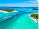 Aerial view featuring a coastal scene with crystal-clear turquoise waters, a bridge, and lush islands and boats at 3608 54Th W Dr # 102, Bradenton, FL 34210
