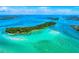 Aerial view displays turquoise waters, boats, and a sandy beach, showcasing recreational boating and beach relaxation at 3608 54Th W Dr # 102, Bradenton, FL 34210