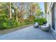 Outdoor patio with wicker furniture surrounded by lush landscaping and serene forest views at 3608 54Th W Dr # 102, Bradenton, FL 34210