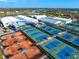 Aerial view of a complex featuring multiple well-maintained tennis courts in blue and orange, perfect for sports enthusiasts at 3608 54Th W Dr # 102, Bradenton, FL 34210