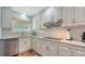 Bright kitchen with white cabinetry, subway tile backsplash, stainless steel appliances, and modern fixtures at 4234 Gulf Of Mexico Dr # Q2, Longboat Key, FL 34228
