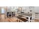 Bright kitchen and dining area featuring white cabinetry, stainless steel appliances, and a rustic dining table at 4234 Gulf Of Mexico Dr # Q2, Longboat Key, FL 34228