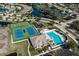 Community aerial view showcasing a pool, clubhouse, tennis, and basketball courts surrounded by lush landscaping and waterways at 4509 Halls Mill Xing, Ellenton, FL 34222