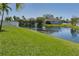 Backyard with pond, fence, and green lawn offers a peaceful setting at 4509 Halls Mill Xing, Ellenton, FL 34222