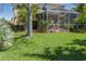 Backyard with screened lanai and lush lawn provides ample outdoor space at 4509 Halls Mill Xing, Ellenton, FL 34222