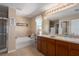 Bright bathroom with double sinks, soaking tub, and glass shower provides a spa-like experience at 4509 Halls Mill Xing, Ellenton, FL 34222