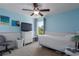 Inviting blue bedroom with a TV, white dresser, ceiling fan, and window views at 4509 Halls Mill Xing, Ellenton, FL 34222