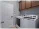 Modern laundry room features a white washer and dryer, white door, and storage cabinets at 4509 Halls Mill Xing, Ellenton, FL 34222