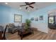 Bright living room features fresh paint, wood flooring, a ceiling fan, and modern decor at 4509 Halls Mill Xing, Ellenton, FL 34222
