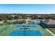 Aerial view of community tennis and basketball courts with a playground and pool nearby surrounded by green spaces at 4509 Halls Mill Xing, Ellenton, FL 34222