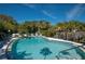 Inviting community pool with lounge chairs and lush tropical landscaping on a bright, sunny day at 5011 Barrington Cir # 101, Sarasota, FL 34234