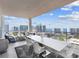 This large balcony features a dining table, lounge area, and stunning waterfront views at 540 N Tamiami Trl # 1503, Sarasota, FL 34236