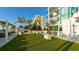 Green common area with artificial grass, modern seating, and decorative palm trees at 540 N Tamiami Trl # 1503, Sarasota, FL 34236