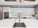 Spacious kitchen with white cabinets, quartz countertops, island seating, stainless steel appliances and modern lighting at 540 N Tamiami Trl # 1503, Sarasota, FL 34236