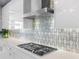 Modern kitchen with stainless steel hood over cooktop and marble backsplash at 540 N Tamiami Trl # 1503, Sarasota, FL 34236