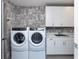 Modern laundry room equipped with washer, dryer, sink, and cabinetry for efficient organization at 540 N Tamiami Trl # 1503, Sarasota, FL 34236