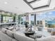 Bright living room featuring a waterfall wall, fireplace, luxury seating, and floor to ceiling water views at 540 N Tamiami Trl # 1503, Sarasota, FL 34236